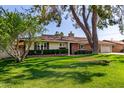 Charming single story home with a well-manicured lawn and mature landscaping surrounding the home at 709 E Hayward Ave, Phoenix, AZ 85020