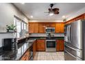 Updated kitchen with stainless steel appliances, granite countertops, and wood cabinets at 7210 W Caron Dr, Peoria, AZ 85345