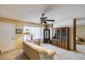 Bright living room featuring a ceiling fan, a large window and built in shelving at 7210 W Caron Dr, Peoria, AZ 85345