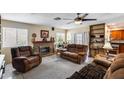 Cozy living room featuring a brick fireplace, comfortable seating and tile flooring at 7210 W Caron Dr, Peoria, AZ 85345