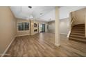 Bright open-concept living room with fireplace, wood flooring, and access to outdoor space at 7272 E Gainey Ranch Rd # 23, Scottsdale, AZ 85258
