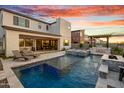 Spacious backyard featuring a pool, spa, outdoor kitchen, and lounge chairs at 826 E Buist Ave, Phoenix, AZ 85042