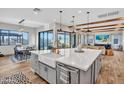Open concept kitchen with island, farmhouse sink, stainless appliances, and hardwood floors at 826 E Buist Ave, Phoenix, AZ 85042