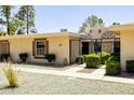 View of the exterior of this single story home with manicured landscaping and gated entry at 10468 W Palmeras Dr, Sun City, AZ 85373