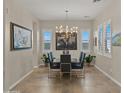 Elegant dining room with modern chandelier, large table, and windows providing natural light at 13820 W Weaver Ct, Litchfield Park, AZ 85340