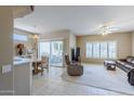 Open-concept living room with neutral tones, large windows, and access to the patio at 15960 W Indigo Ln, Surprise, AZ 85374