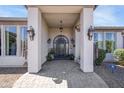 Welcoming entrance with an ornate front door, pendant lighting, and neatly manicured landscaping at 16645 W Papago St, Goodyear, AZ 85338