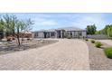 Beautiful single-story home featuring a paver driveway and desert landscaping in a sunny setting at 16645 W Papago St, Goodyear, AZ 85338