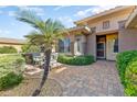 Charming courtyard with brick pavers, lush greenery, and a cozy outdoor seating area at 16857 W Villagio Dr, Surprise, AZ 85387