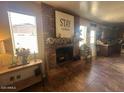 Living room featuring a brick fireplace, mantle decorations and open access to the adjoining kitchen at 1841 S Spruce --, Mesa, AZ 85210