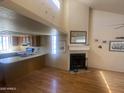 Bright living room featuring a fireplace, hardwood floors and view of the kitchen at 2020 W Union Hills Dr # 240, Phoenix, AZ 85027