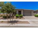 Inviting single-story home with desert landscaping and a well-manicured lawn at 21824 S 226Th Pl, Queen Creek, AZ 85142