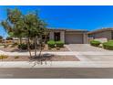Attractive one-story home featuring desert landscaping, and a spacious driveway at 21824 S 226Th Pl, Queen Creek, AZ 85142