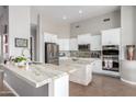 Bright, modern kitchen with white cabinets, stainless steel appliances, and beautiful stone countertops at 2308 E Dry Wood Rd, Phoenix, AZ 85024