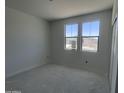 An empty bedroom, offering a bright interior with a large window and neutral walls at 24104 W Bowker St, Buckeye, AZ 85326