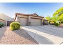 Three-car garage with desert landscaping at 26330 N 56Th Dr, Phoenix, AZ 85083