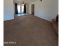 Large living room with carpet flooring, decorative brick fireplace, and French door access to backyard at 2934 W Northview Ave, Phoenix, AZ 85051