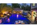 Gorgeous pool with fire bowls, waterfalls, lush landscaping, a swim up bar and several seating areas at 2985 N Point Ridge Rd, Buckeye, AZ 85396