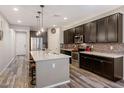 Spacious kitchen with dark cabinets, center island, granite counters, and stainless steel appliances at 3048 W Thorn Tree Dr, Phoenix, AZ 85085