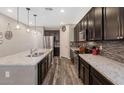 Beautiful kitchen featuring dark cabinets, stainless appliances, an island with a sink and granite countertops at 3048 W Thorn Tree Dr, Phoenix, AZ 85085
