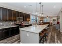 Modern kitchen with dark cabinets, granite countertops, stainless steel appliances and center island with seating at 3048 W Thorn Tree Dr, Phoenix, AZ 85085