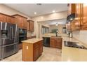 Well-equipped kitchen showcasing stainless steel appliances, an island, and warm wood cabinetry at 3819 N Springfield St, Buckeye, AZ 85396