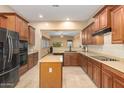 Well-equipped kitchen showcasing stainless steel appliances, an island, and warm wood cabinetry at 3819 N Springfield St, Buckeye, AZ 85396
