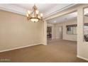 Spacious living room featuring an elegant chandelier, neutral paint, and an open floor plan at 3819 N Springfield St, Buckeye, AZ 85396