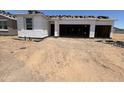 Image of new home's exterior with two-car garage, window openings, and the initial stages of roof installation at 46850 W Old Timer Rd, Maricopa, AZ 85139