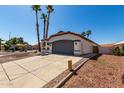 Lovely single-story house showcasing a driveway, terracotta roof, and desert landscaping at 5125 W Wickiup Ln, Glendale, AZ 85308