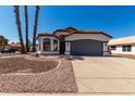 Inviting single-story home with a two-car garage, terracotta roof, and desert-friendly front yard at 5125 W Wickiup Ln, Glendale, AZ 85308
