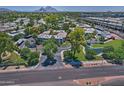 Expansive aerial view of Cloisters Condominiums with lush landscaping, pond, and Camelback Mountain in the background at 5203 N 24Th St # 207, Phoenix, AZ 85016