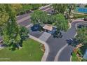 Aerial view showcases a guard house with green landscaping, palm trees, and proximity to a street at 5203 N 24Th St # 207, Phoenix, AZ 85016