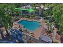This aerial view highlights a community pool area with chairs, lush landscaping, and spa at 5203 N 24Th St # 207, Phoenix, AZ 85016