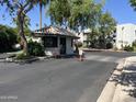 View of the community gate house, trees and well maintained exterior at 5203 N 24Th St # 207, Phoenix, AZ 85016