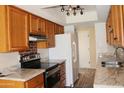 Well-lit kitchen with modern appliances, granite countertops, wood cabinets, and tile flooring at 5529 W Zoe Ella Way, Glendale, AZ 85306