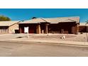 Inviting single-story home with a red garage door, desert landscaping, and tile roofing at 6302 E Portia St, Mesa, AZ 85215