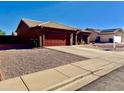 Cozy single-story home with red garage and desert landscaping offers great curb appeal at 6302 E Portia St, Mesa, AZ 85215