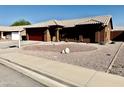 Well-maintained single-story home with desert landscaping and a red garage door at 6302 E Portia St, Mesa, AZ 85215