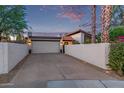 Home exterior showing the garage, front gate, and privacy walls at dusk at 7821 N Via De La Sombre --, Scottsdale, AZ 85258