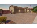 Side view of the property showing brick driveway, three car garage and desert landscaping at 1036 W Siebold Tree Ave, Queen Creek, AZ 85140