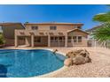 The home features a sparkling pool, covered patio and lush landscaping, offering a private outdoor retreat at 11511 E Renata Ave, Mesa, AZ 85212