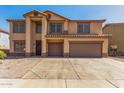 Two-story tan home featuring a two-car garage, desert landscaping, and a concrete driveway at 11511 E Renata Ave, Mesa, AZ 85212