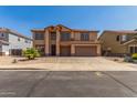 Front exterior view of a two-story tan home with a two-car garage, desert landscaping, and a paved driveway at 11511 E Renata Ave, Mesa, AZ 85212