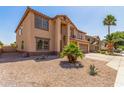 Two-story home featuring a neutral stucco exterior, a two-car garage, and a low-maintenance desert landscape at 11511 E Renata Ave, Mesa, AZ 85212