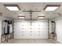 Spacious garage featuring a white door, overhead lighting, and durable epoxy flooring at 11737 N 143Rd Dr, Surprise, AZ 85379