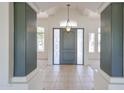 Inviting foyer with neutral tile flooring, decorative columns, and a stylish front door with sidelights at 12721 W Georgia Ave, Litchfield Park, AZ 85340