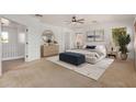 Bright main bedroom featuring neutral decor, carpet, and a stylish round mirror above a light wood dresser at 13599 W Monte Vista Rd, Goodyear, AZ 85395