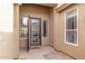 Covered entryway featuring a modern steel entry door with sidelights and stacked stone pavers at 139 E Gail Dr, Gilbert, AZ 85296