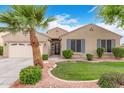Inviting single-story home featuring a two car garage, desert landscaping and a mature palm tree at 139 E Gail Dr, Gilbert, AZ 85296